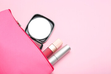 Cosmetic bag with pocket mirror and makeup products on pink background, flat lay. Space for text
