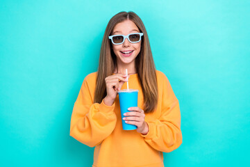 Photo of young teen cute girl wear orange sweater hold drink soda cup wear 3d glasses watching...