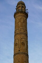 Tall minaret with decorative carvings on its sides in The Great Mosque of Mardin in Turkey