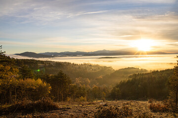 Fototapeta na wymiar sunrise over a mountain below a misty valley