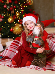 Fototapeta na wymiar Little girl happily embraces Santa Claus