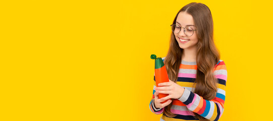 kid in glasses open shower gel. happy teen girl use shampoo bottle. child with hair conditioner. Banner of child girl hair care, studio poster header with copy space.