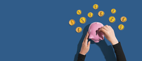 Fototapeta premium Person depositing money in a pink piggy bank