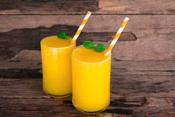 Mango juice fruit smoothies yogurt drink yellow healthy delicious taste in a glass slush for weight loss on wooden background.