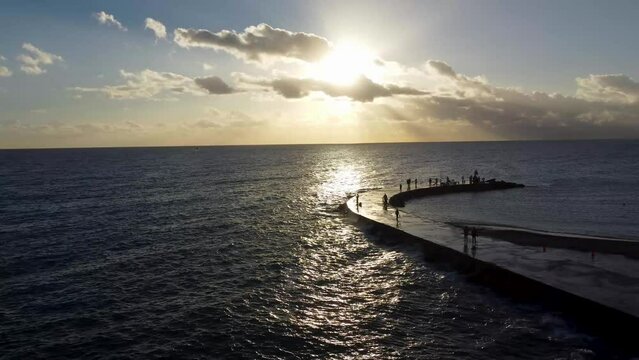 Sunrise at Baker's Haulover Inlet and park & Bal Harbour Miami - Drone Footage - Flying accross the ocean - people standing on inlet