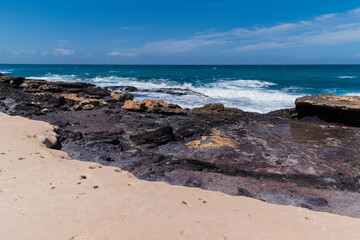 Fototapeta na wymiar Huge dark rocky beach with many savage Atlantic ocean waves, Fuerteventura 