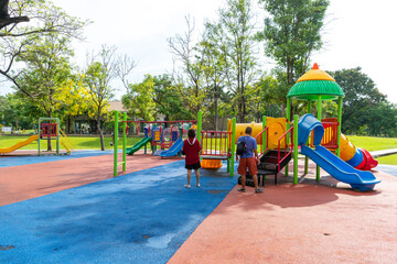 Fototapeta na wymiar Bangkok, Thailand - April 24, 2022 : Children and family happily have fun at playground in public park in Bangkok, Thailand on April 24, 2022.