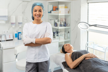 Young woman, cosmetology doctor in white uniform posing at beauty clinic