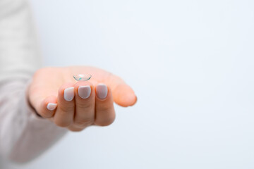 Contact lens in woman hands with copy space. Healthcare and eye care concept. 