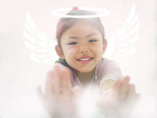 Little child girl pretend play to fly with wings on her back through clouds in her imagination. Child enjoys imagining or dreaming while playing.