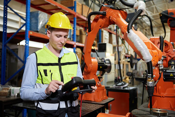 factory worker or engineer operating remote switch controller to control robot machine in the factory