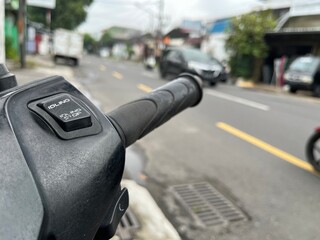 Closeup view of motor cycle handle bar on the side of the street.