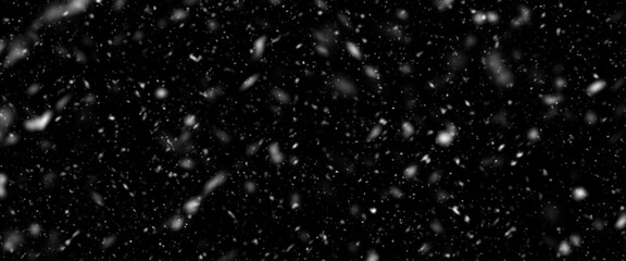 Snowfall bokeh on black background. Many snowflakes in flying in the air. Winte night snowfall and blizzard of snow at. Blur bokeh light effect creative background.