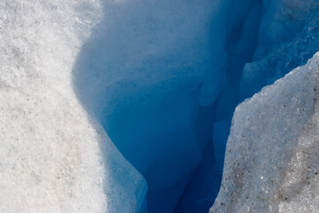 Close up of crack in glacier showing blue layers of ice and snow