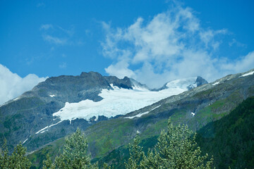 blue skies white clouds glacier in the valley of an Alaskan Mountain