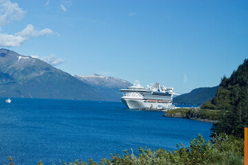 A large passenger ship in the water channel with snowy mountains in Alaska