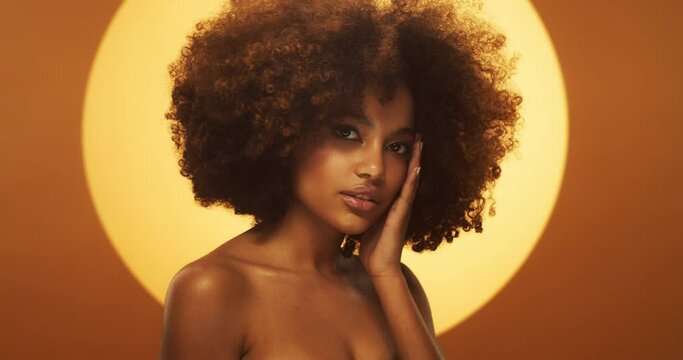 Beauty portrait of african american woman with beautiful afro hairstyle, curly black hair, isolated on brown background