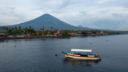 Boat anchored in the Bali sea and a mountain volcano Agung in the background
