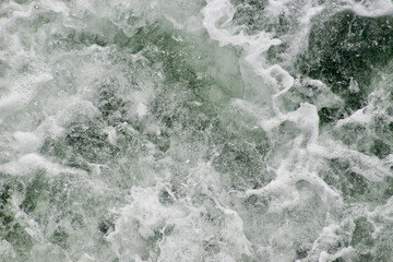Fototapeta na wymiar water churning in a wake and foaming