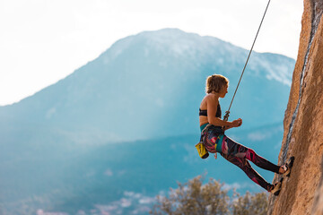 girl rock climber hanging on a rope.