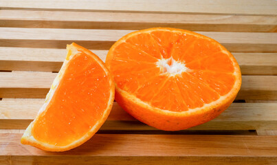 Fresh orange on a wooden chopping board isolated on a white background.