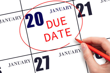 Hand writing text DUE DATE on calendar date January 20 and circling it. Payment due date