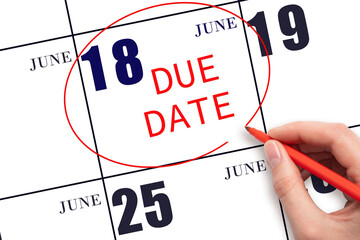 18th day of June. Hand writing text DUE DATE on calendar date June 18 and circling it. Payment due date. Business concept. Summer month, day of the year concept.