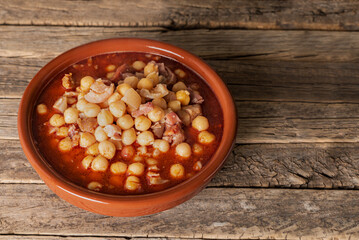 Clay dish with tripe and chickpeas,on an old wooden background,close-up.