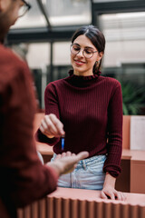 Businesswoman holding and giving a token for the door opening, to the male coworker.