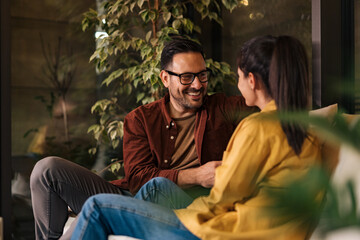Obraz premium Businessman and businesswoman enjoying their break from work, talking to each other, sitting.