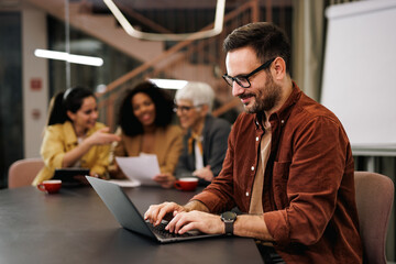 Businessman working over the laptop, at the office, typing over the laptop.