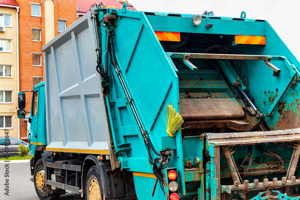 Poster A garbage truck picks up garbage in a residential area. Loading mussar in containers into the car. Separate collection and disposal of garbage. Garbage collection vehicle.