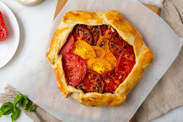Top view of tomatoes savory pie tart on wooden board vegan food