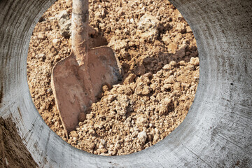Construction shovel in a pile of sand close-up. Working building tool. Builder's hand tool. Sand...
