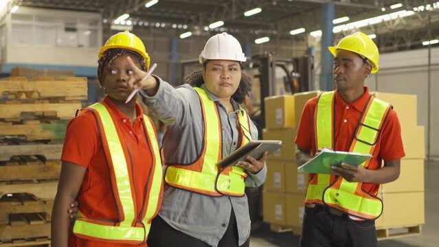 Teamwork of black workers and fat woman working in large warehouse retail store industry. Rack of stock storage. Interior of cargo in ecommerce and logistic. Depot. People lifestyle. Shipment service.