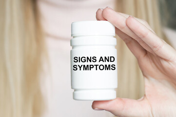 SINGS AND SYMPTOMS text on a white jar in the hands of a girl's doctor. Medical concept.