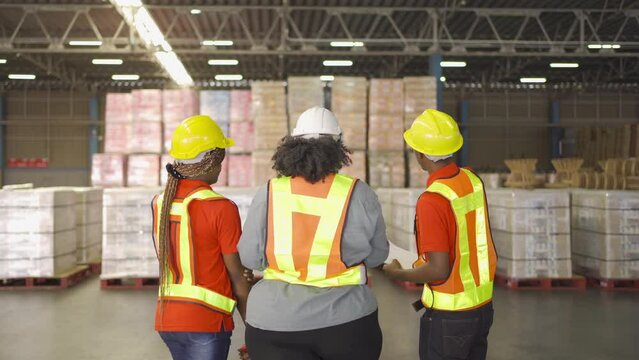 Teamwork of black workers and fat woman working in large warehouse retail store industry. Rack of stock storage. Interior of cargo in ecommerce and logistic. Depot. People lifestyle. Shipment service.