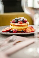Vertical shot of delicious pancakes with berries on a plate