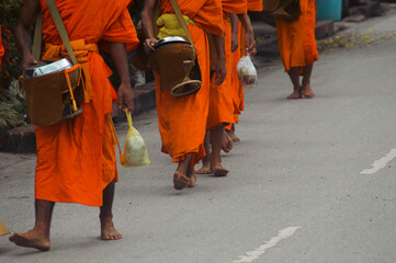Buddhist monks during Sai Bat or Tak Bat, the traditional morning alms giving ceremony in Luang...