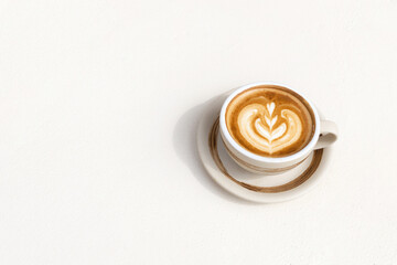A cup of hot latte art or cappuccino coffee on white background