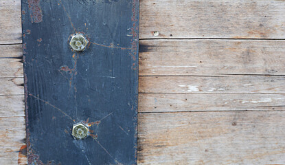 Steel plates and wood are fastened together with nuts.