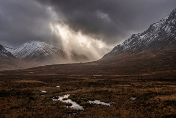 Majestic dramatic Winter sunset sunbeams over landscape of Lost Valley in Etive Mor in Scottish Highlands - 549180486