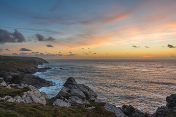 Stunning sunset landscape image of Cornwall cliff coastline with tin mines in background viewed from Pendeen Lighthouse headland