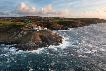 Stunning aerial drone landscape image of Pendeen Lighthouse in Cornwall at sunset with beautiful colors and sky