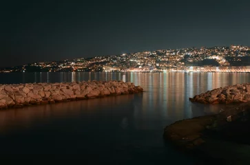 Foto op Plexiglas Stad aan het water Beautiful scenery of the city lights reflecting in sea at night, Naples, Italy