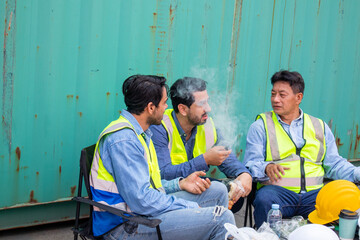 A Group of multiethnic male workers teams taking a break and rest sitting at the workplace