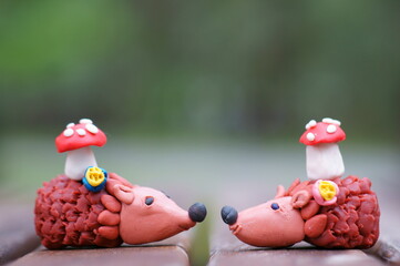 Two toy hedgehogs with mushrooms.