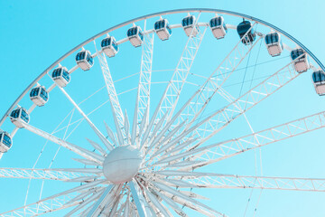 White ferris wheel on a blue pastel  sky background