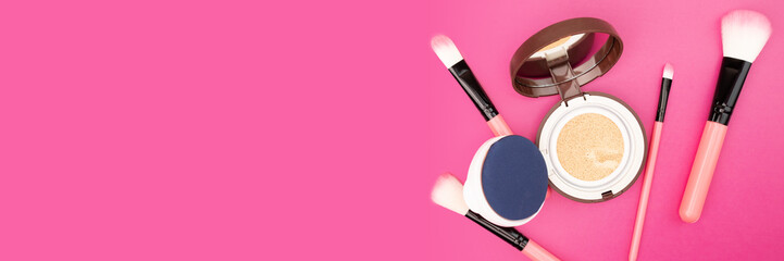 cushion cosmetic with makeup brushes on a pink background,banner