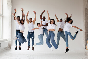 Group of young diverse People dancers jumping on white background in studio. Guys and girls in...